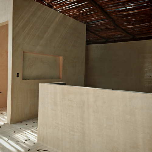 Muros interiores con acabado de chukum en tono natural.